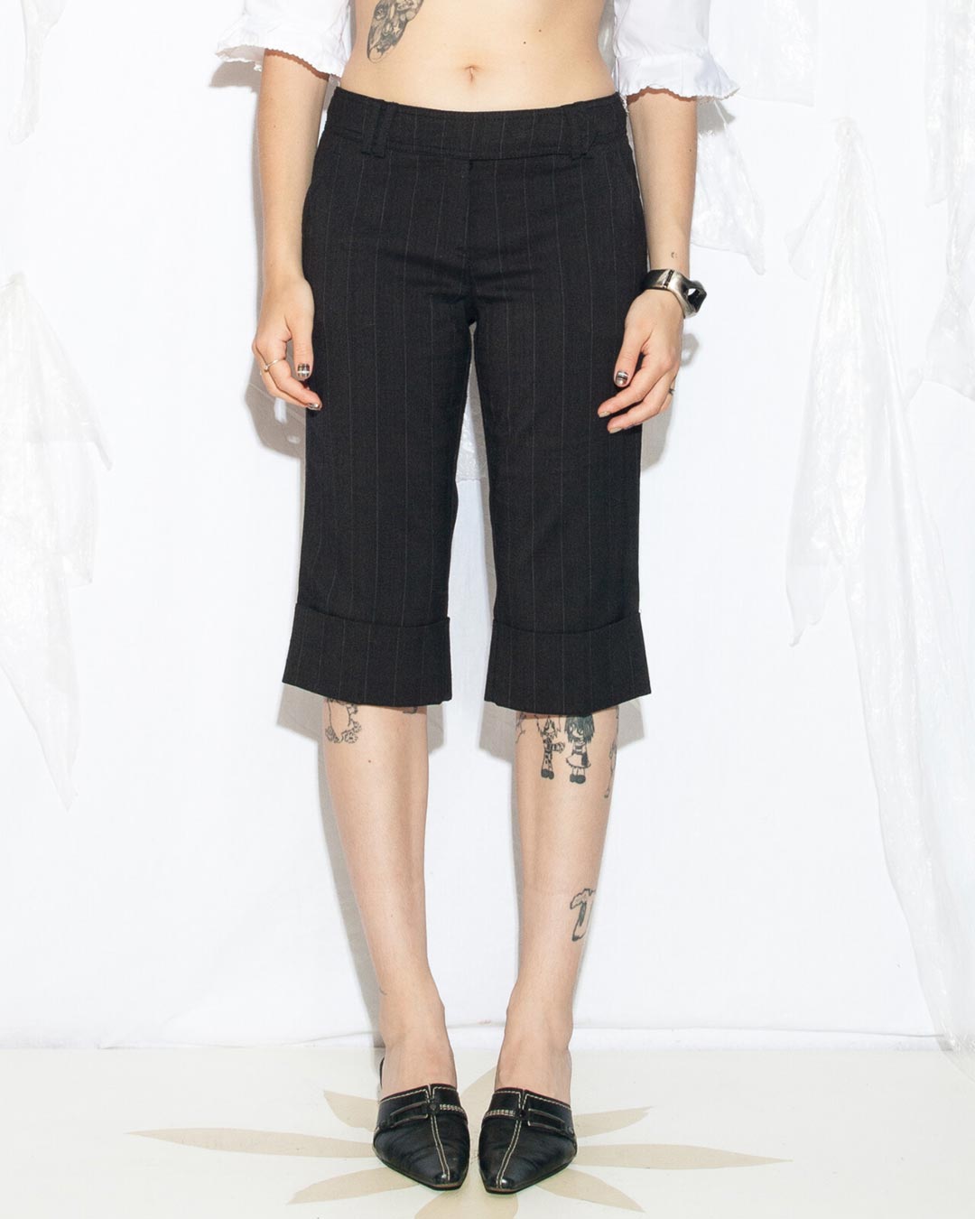 Photo of a female model wearing short black capri pants